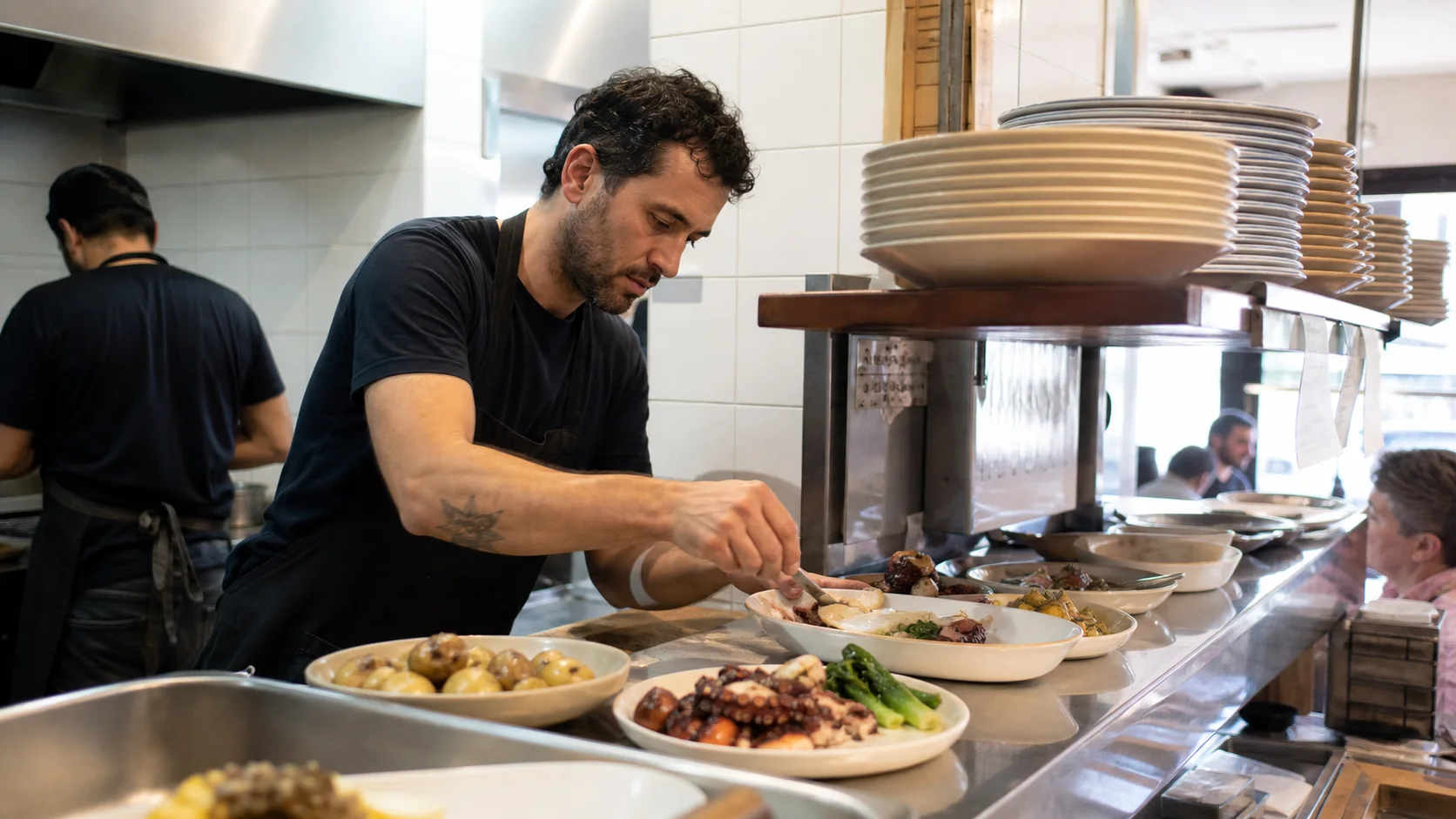 Cook plating dishes at the kitchen pass